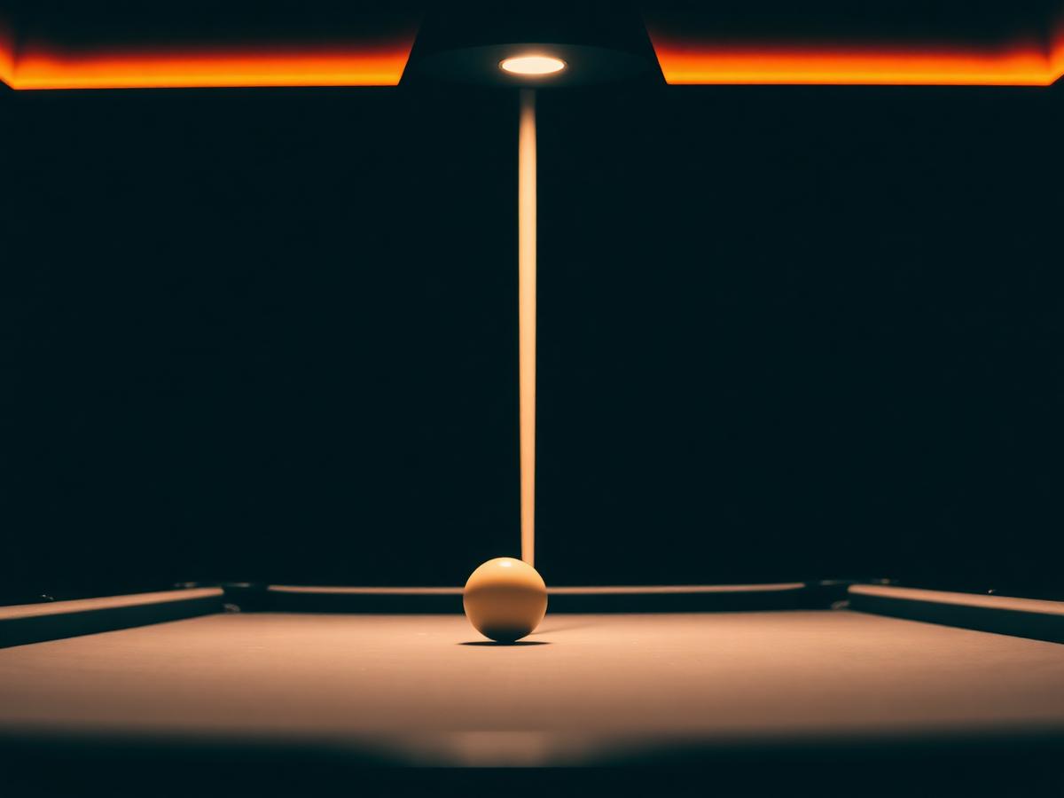 Pool cues lined up next to a green slate pool table